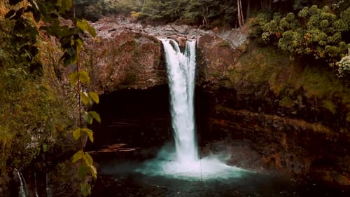 Rainbow Fall Water Fall Surrounded By Green Foliage In Hilo Hawaii