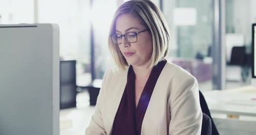 4k footage of a happy businesswoman working behind her computer screen in the office