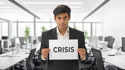 Angry Indian manager holding CRISIS banner