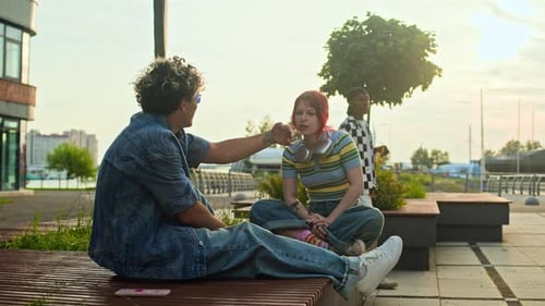 Gen Z Friends Gossiping about Black Skateboarder Passing Them by on City Street
