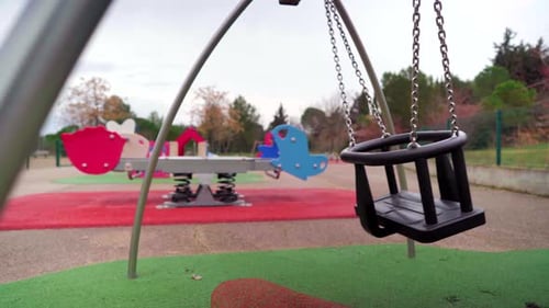 Empty baby swing in a children playground during Covid-19 coronavirus pandemic lockdown