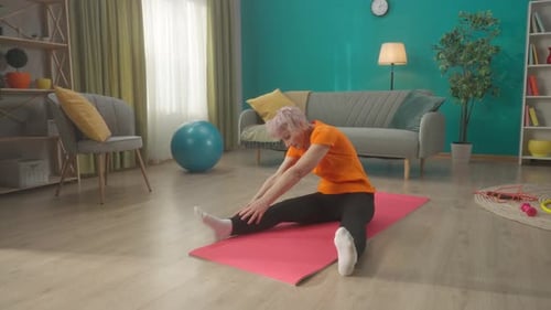 Senior Woman Stretching on Yoga Mat at Home