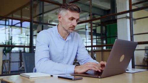 Focused Middle Aged Business Man Typing on Computer Working in Modern Office
