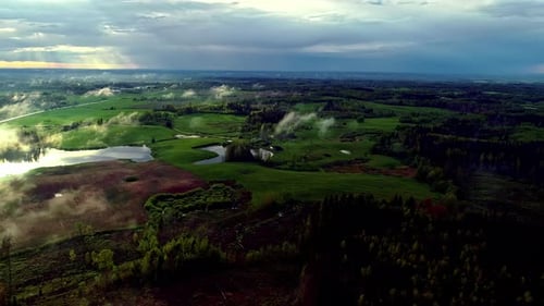 Aerial View Of Green Rural Landscape On A Cloudy Sunset.