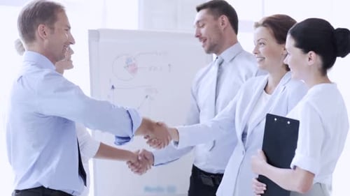 Businessmen and businesswomen shaking hands after a successful meeting in the office