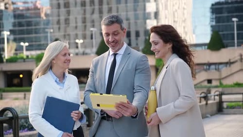 Business People Discussing Technology Outside Office Building