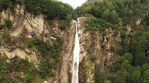 Aerial view of an incredible steep waterfall surrounded by the lush vegetation of the forest
