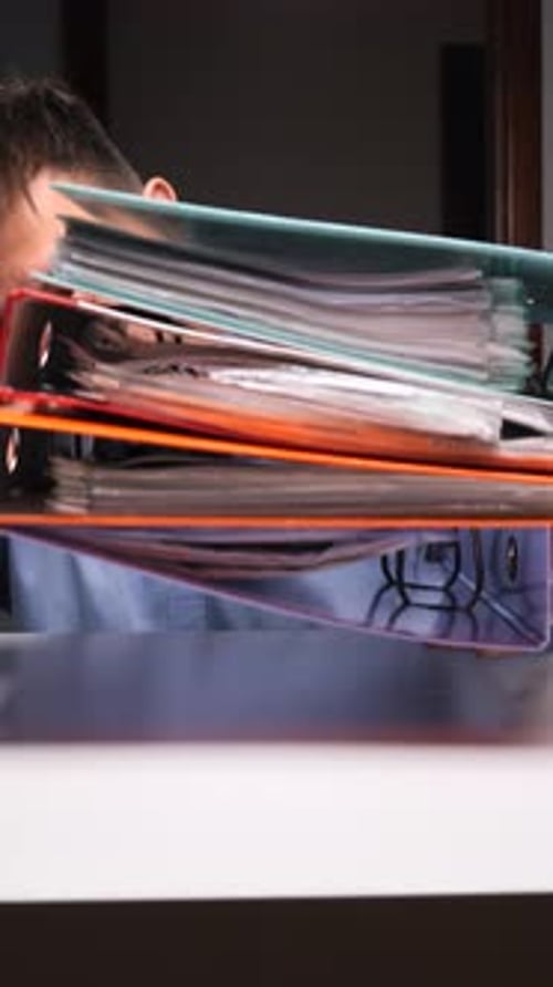 Vertical Video Man Struggling Under Heavy Load of Office Paperwork