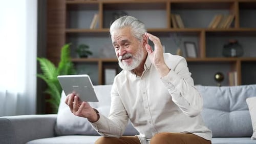 Senior Man Video Calling on Tablet Indoors