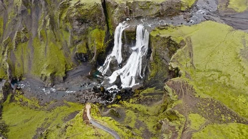 Aerial view of the cascading waterfall plunges down rugged cliffs, creating a mesmerizing spectacle