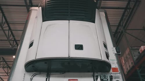 low angle of a front reefer trailer sitting in a repair shop of a truck and trailer maintnance build