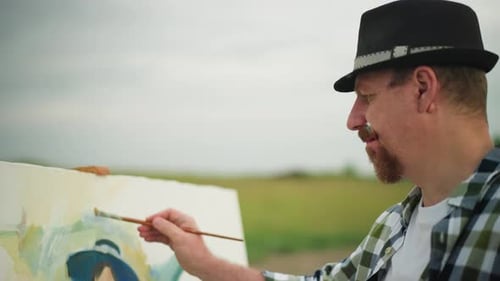 Focused Artist Painting Outdoors in Rural Setting