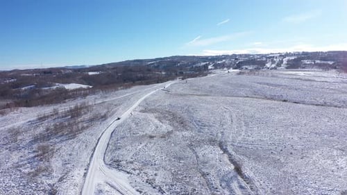 Aerial View of Car Driving on a Winter Road. Winter Countryside Landscape