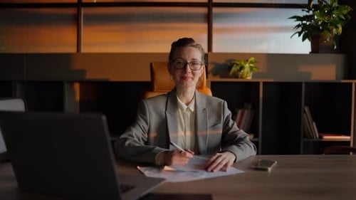 Smiling Woman at Her Desk in Warm Sunlight