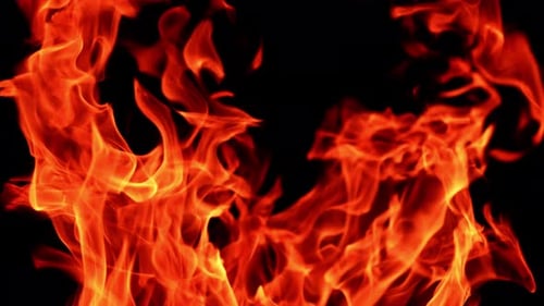 Dangerous red flames moving to the sides close up. Hot fire burning at night.