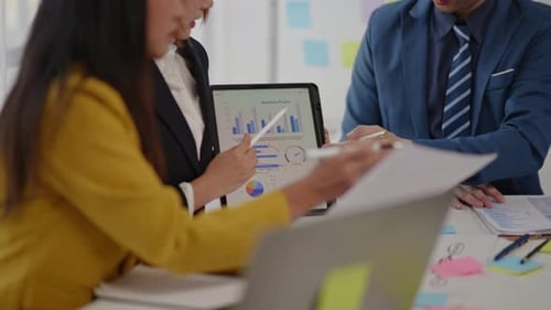 Colleagues Collaborate on Business Data Analysis in Office