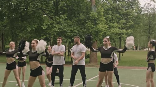 Pirámide de porristas bailando y actuando en un campo deportivo
