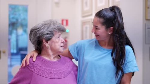 Young Woman with her arm around Senior Woman Smiling