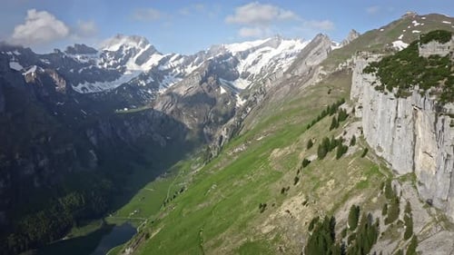 Amazing lush green valley with mountains rising above on a clear beautiful day. Drone aerial shot in
