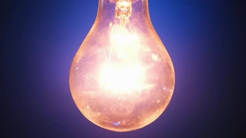 Incandescent Lamp Lights Up and Flickers on Blue Background