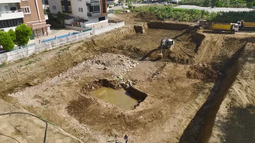 Construction Site with Excavator and Dump Truck Aerial View