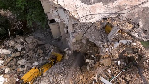 Excavator arm demolishing an old building, Aerial view