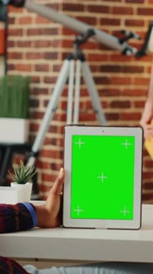 Hand Holding Tablet with Green Screen Indoors