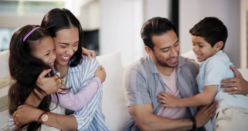 Happy Family Hugging on a Couch Indoors