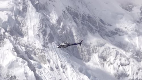 Helicopter Flying Near Rocky Mountain Peak