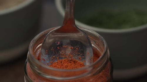 Scooping Paprika Powder Using Tablespoon. - Close Up Shot