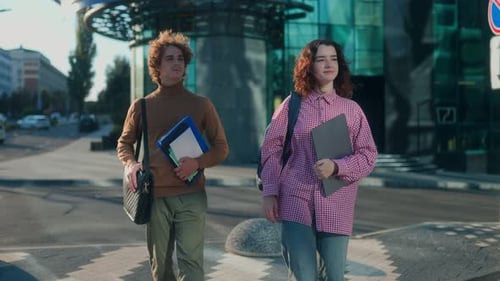 Focused Young Students Standing with Books Outside Modern College Campus