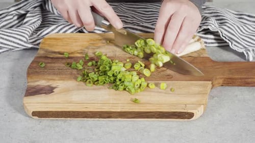Cutting Organic Green Onions on a Wood Cutting Board