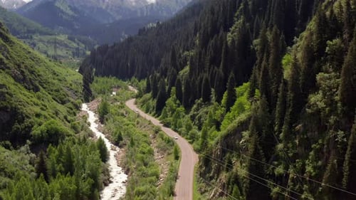 Car Driving Along Mountain Road Beside River in Green Valley Scenic Summer Travel Destination
