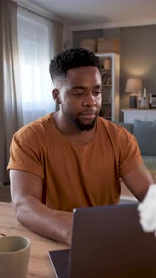 Young Man Working on Laptop at Home