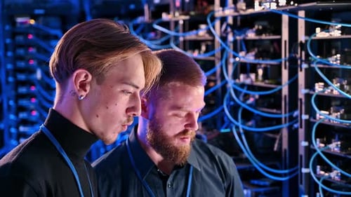 Two Men Working in Server Room at Night