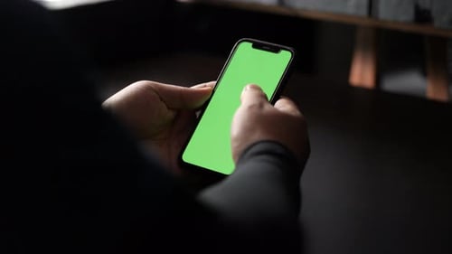 Close up and slide movement of a man using a smartphone. Chroma key green screen on the smartphone s