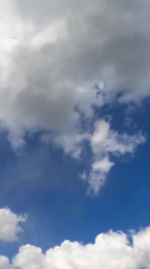 Fluffy Clouds Moving Across a Blue Sky