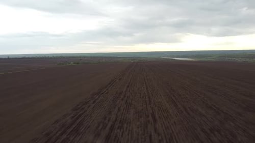 Blue tractor OA working on the field in Ukraine