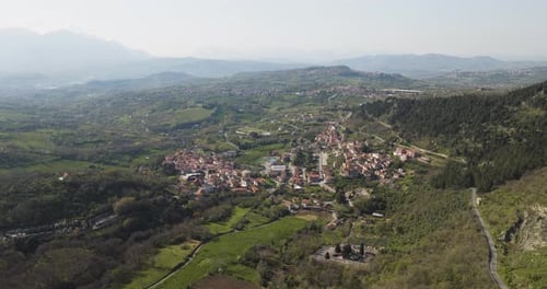 Aerial view of rural town surrounded by hills, Italy.