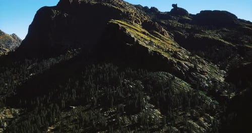 A Stunning View of Rugged Mountain Peaks Adorned with Vibrant Greenery