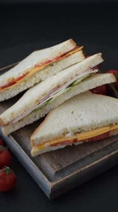 Sandwich Halves on Wooden Board with Cherry Tomatoes