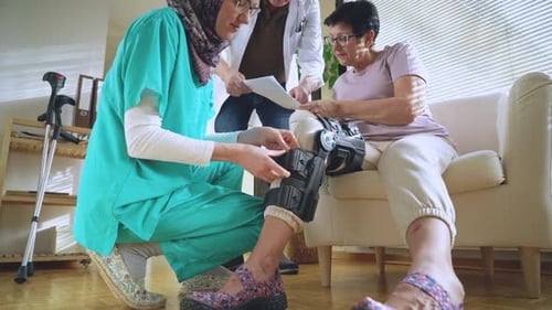 Physical Therapist Fitting Leg Brace for Patient