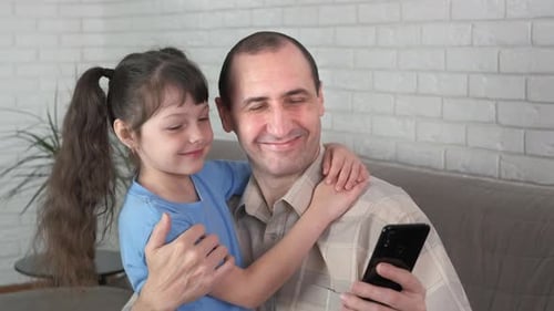 Father and Child Using Smartphone Together at Home