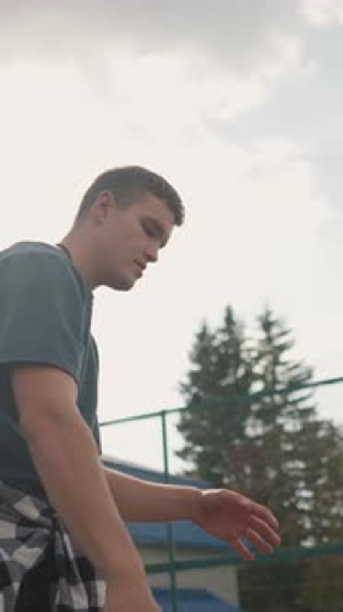 Young Man Practices Serving Volleyball on Outdoor Court