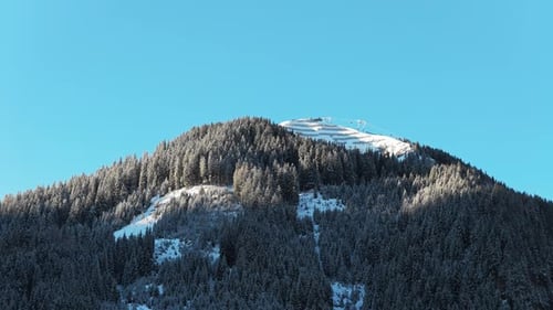 Aerial View Revealing Sunny Snow Covered Peak with Ski Lift in the Austrian Alps Near Saalbach on a