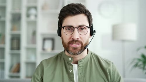Webcam view. Confident businessman in wireless headset talking on a video call looking at camera