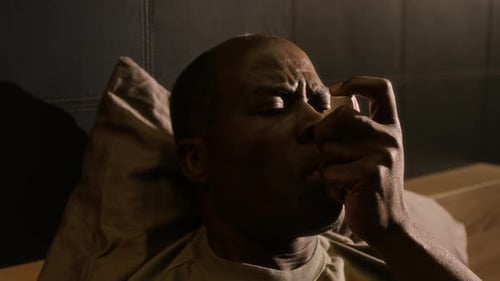 Man Suffering from Asthma Attack Using Inhaler in Bed