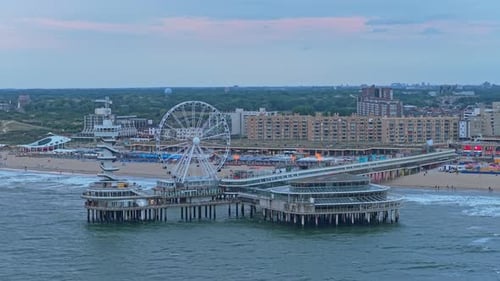 Sunset aerial of Scheveningen Pier with Ferris wheel over shimmering sea,