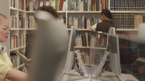 Two Students Browsing Online for Information for Graduate Thesis in Library