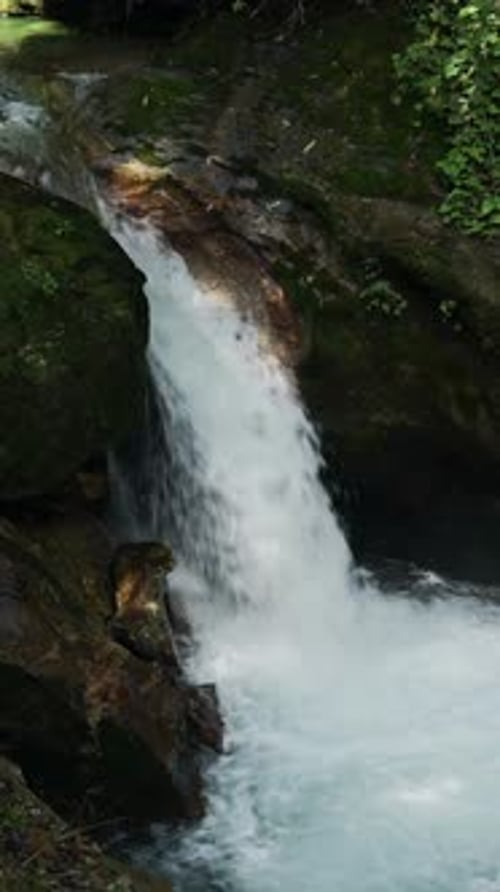 Vertical Small Waterfall Close Up, River of Water Flowing over Rocky Rocks Vertical Video for Social